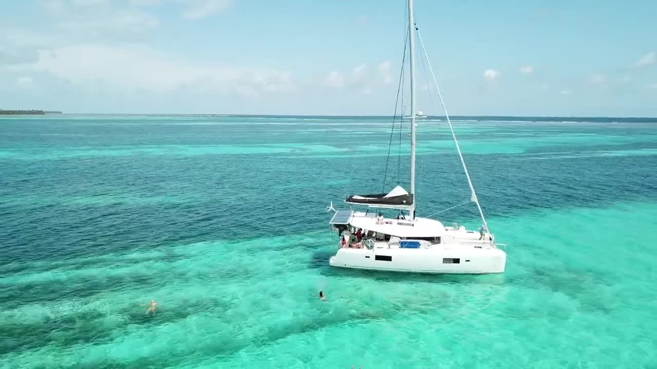 Catamaran anchored in clear turquoise water over the reef in San Blas