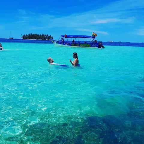 Guests in the natural pool next to the lancha
