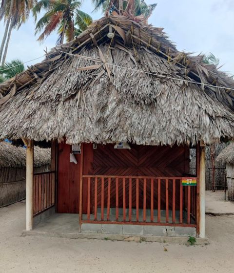 A thatched cabin with a wooden porch