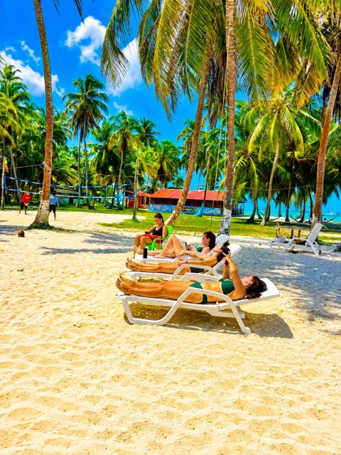 Guests on sun loungers on the white sand