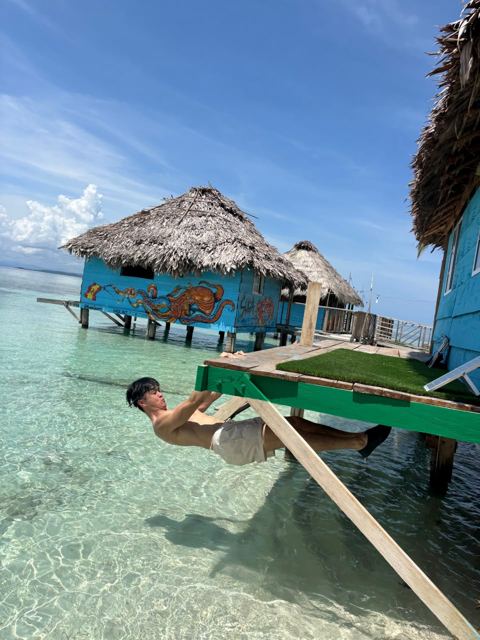 Guest playing on a hammock net over the water
